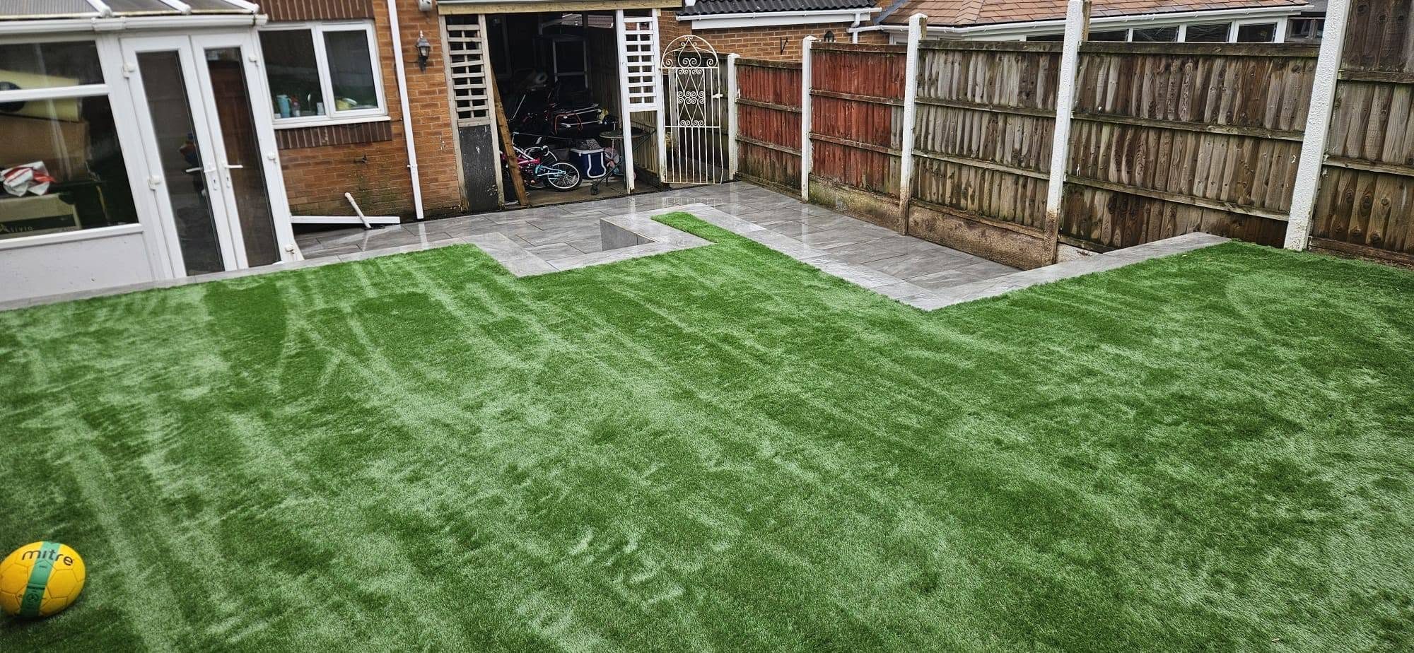 Artificial grass lawn meeting a porcelain patio