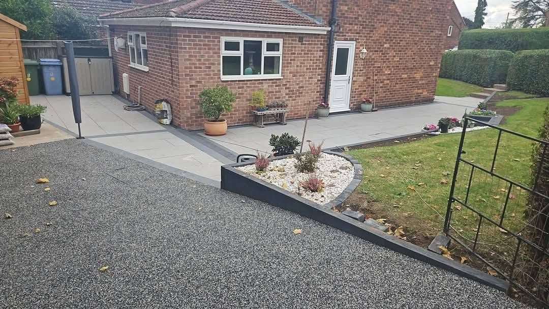Resin bound driveway with a raised planting bed and grey porcelain patio