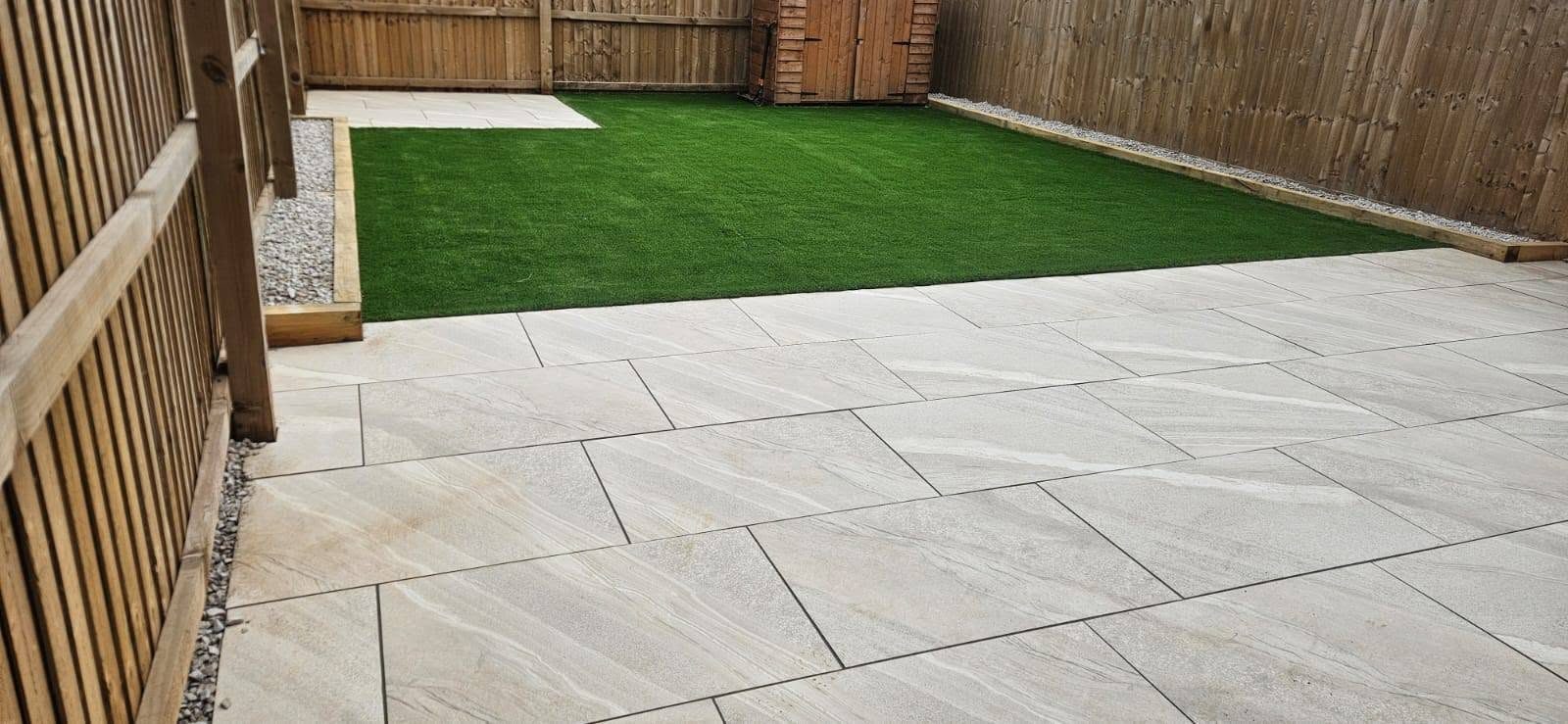 Cream porcelain patio next to an artificial grass lawn