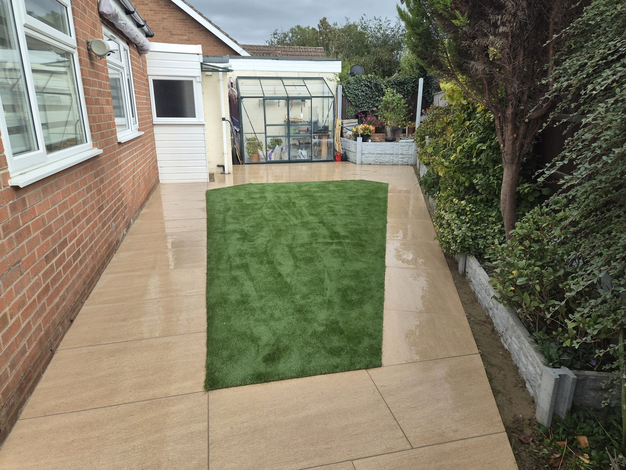 Beige porcelain side garden with an artificial grass panel