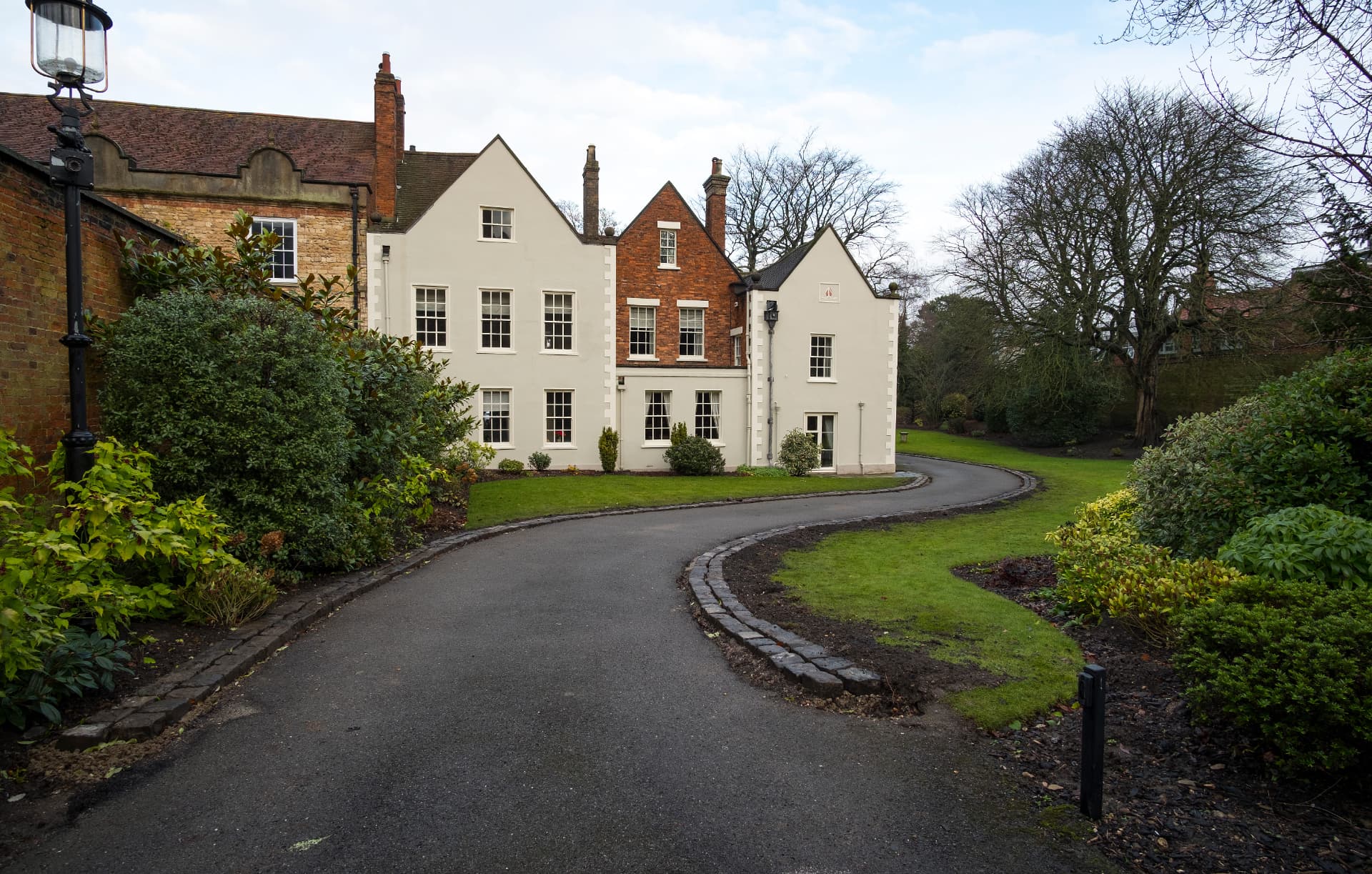 Curving tarmac driveway leading to a large house