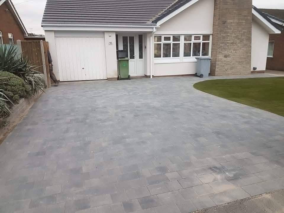 Grey block paving driveway in front of a bungalow garage