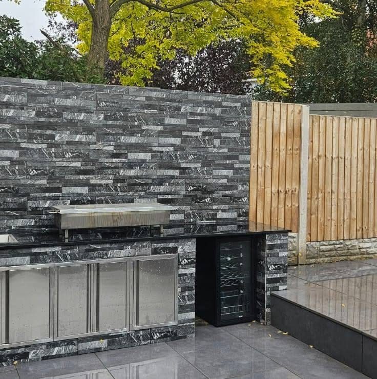 Outdoor kitchen with stone cladding and porcelain paving