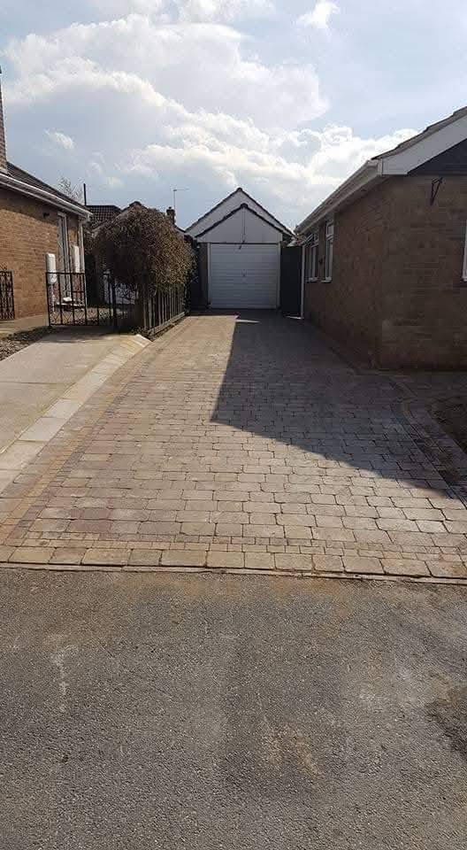 Block paving driveway leading to a detached garage