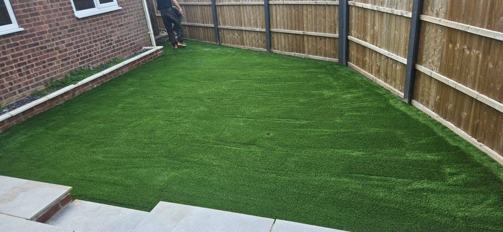Artificial grass lawn in a fenced back garden