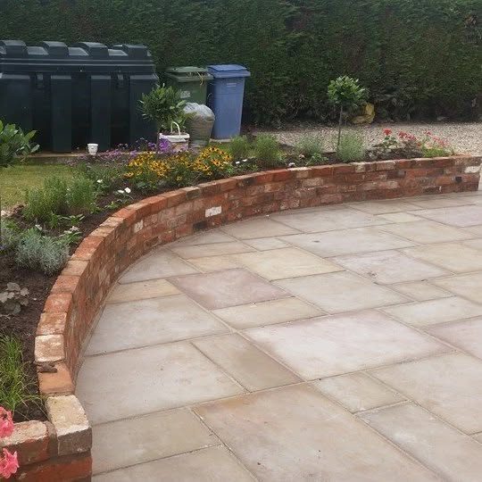 Indian stone patio edged by a curved brick wall